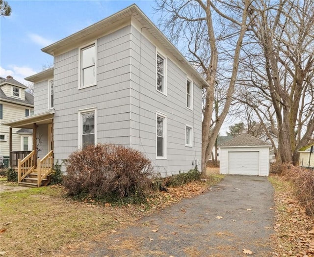 view of home's exterior with covered porch, an outdoor structure, and a garage