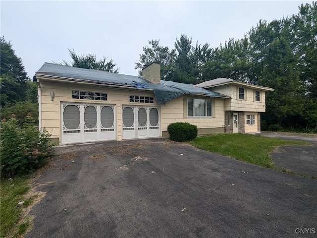 tri-level home featuring a front yard and a garage