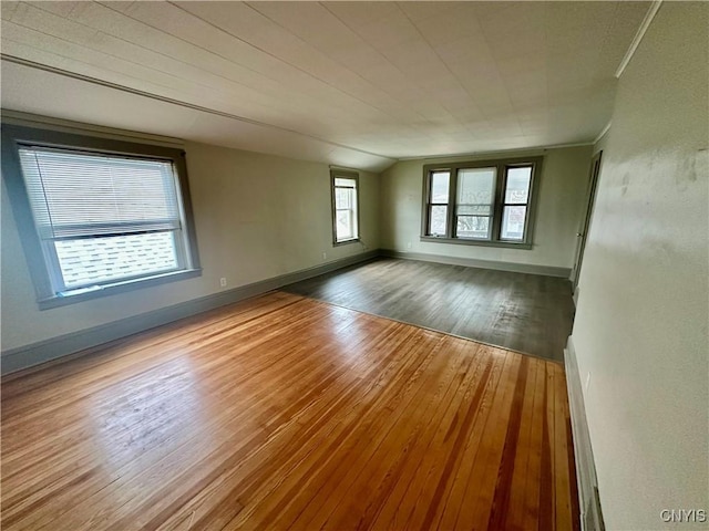 unfurnished room featuring wood-type flooring and vaulted ceiling