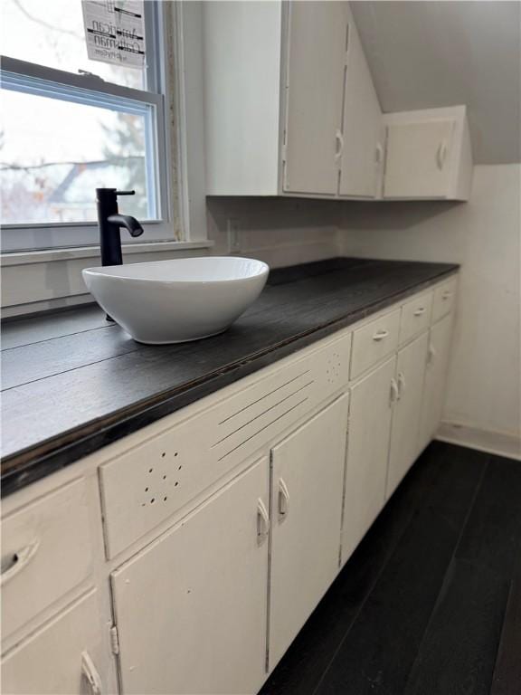 kitchen featuring white cabinets, dark hardwood / wood-style flooring, and sink