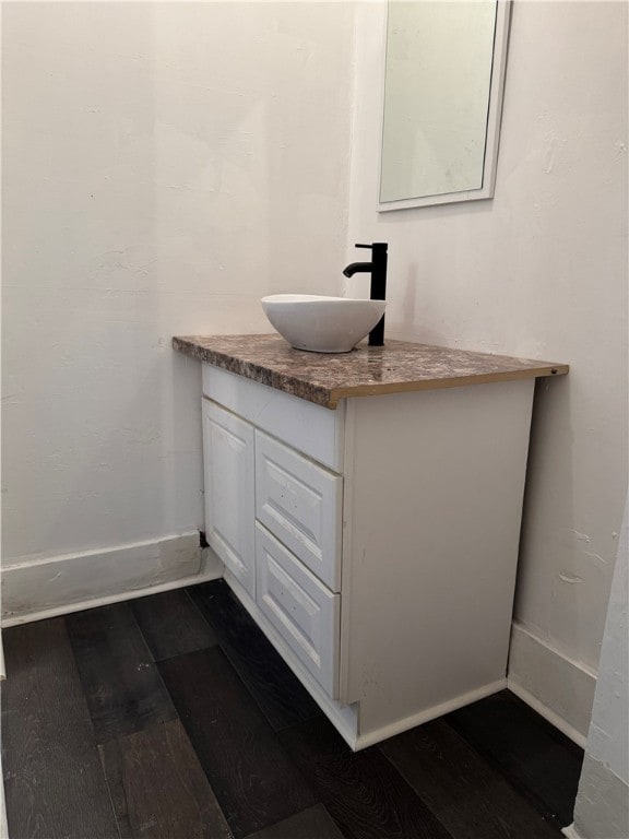 bathroom with vanity, baseboards, and wood-type flooring