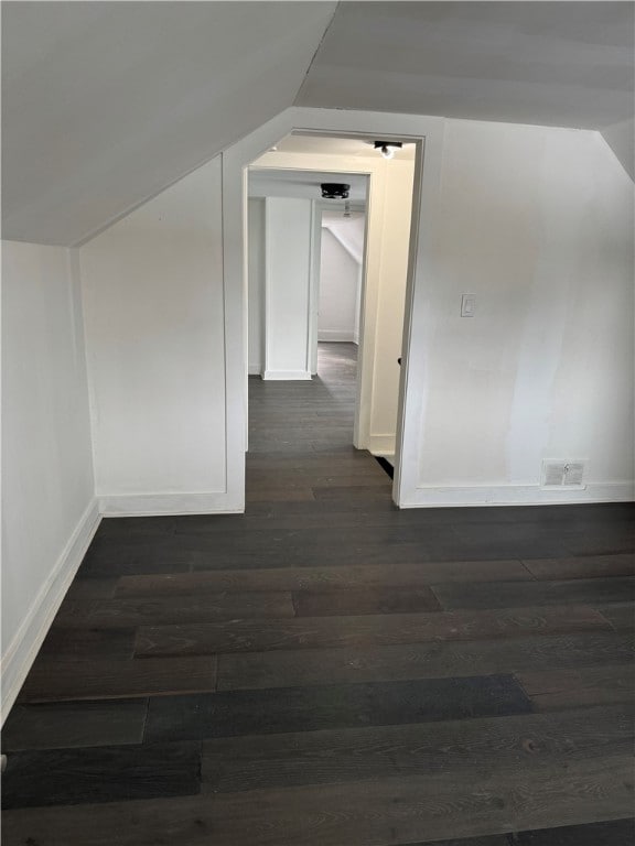 bonus room with dark hardwood / wood-style flooring and vaulted ceiling