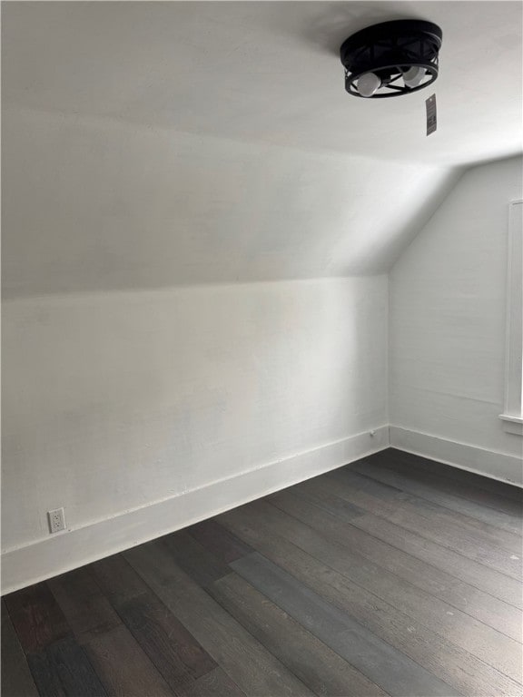 bonus room featuring baseboards, dark wood-type flooring, and lofted ceiling