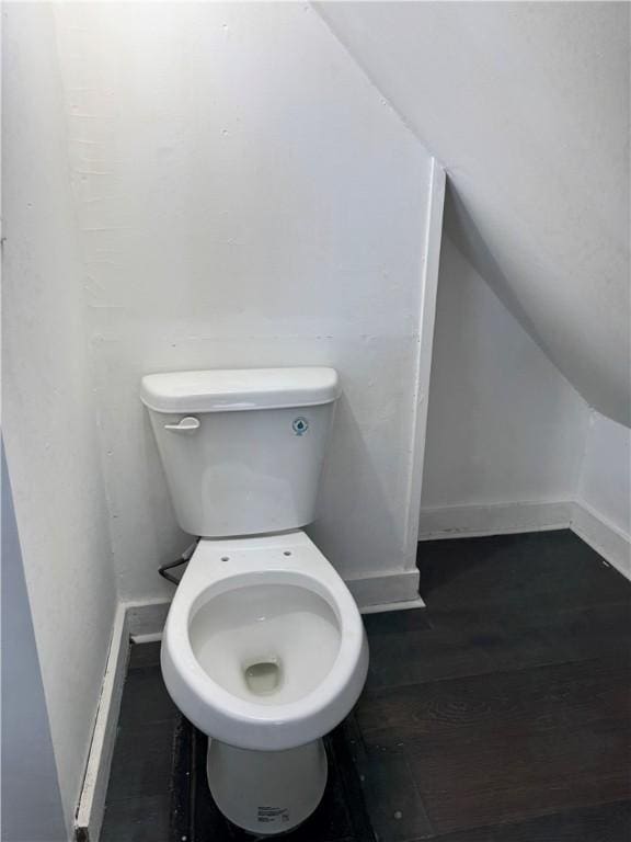 bathroom featuring baseboards, toilet, lofted ceiling, and wood finished floors