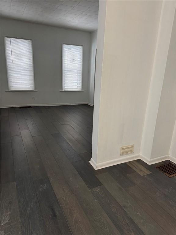 empty room with dark hardwood / wood-style flooring