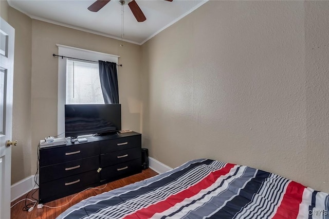 bedroom with ceiling fan, ornamental molding, and dark wood-type flooring