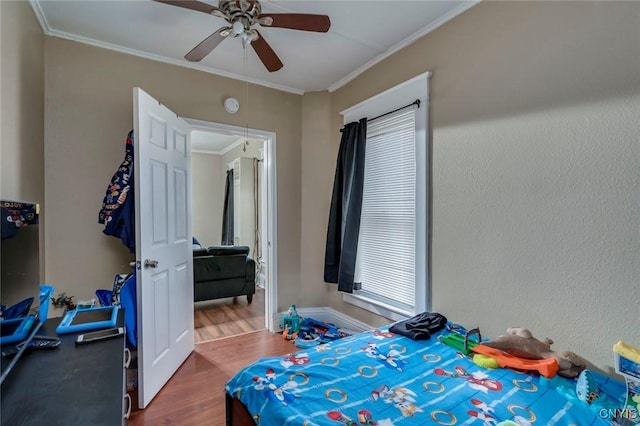 bedroom with ceiling fan, wood-type flooring, and ornamental molding