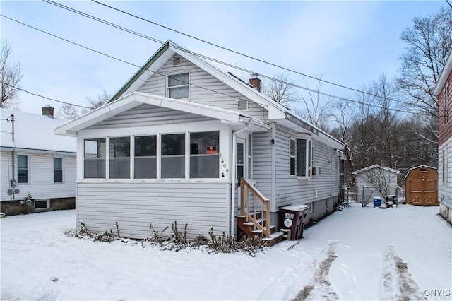 bungalow-style house featuring a storage unit