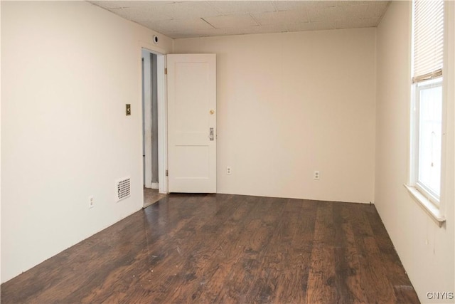 unfurnished room with dark wood-type flooring