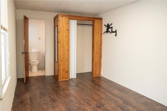 unfurnished bedroom with dark hardwood / wood-style floors, a closet, and ensuite bathroom