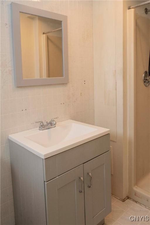 bathroom with tile patterned flooring, vanity, and tile walls