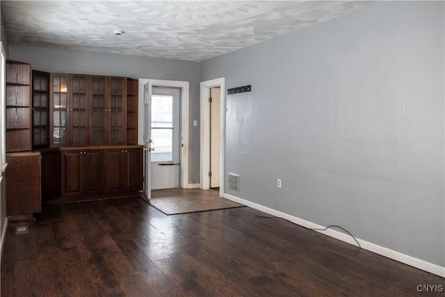 foyer entrance with a textured ceiling and dark hardwood / wood-style floors