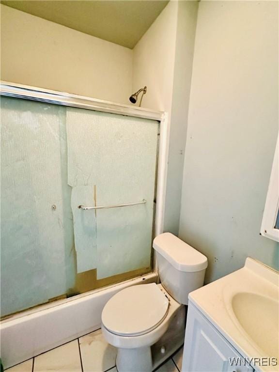 full bathroom featuring tile patterned floors, shower / bath combination with glass door, vanity, and toilet