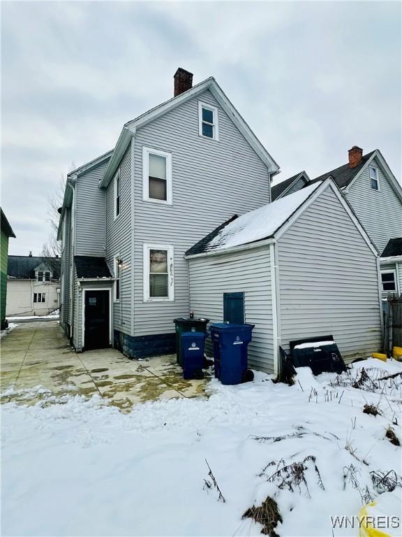 view of snow covered rear of property