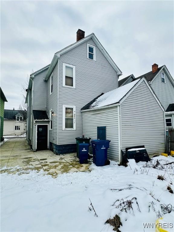 view of snow covered rear of property