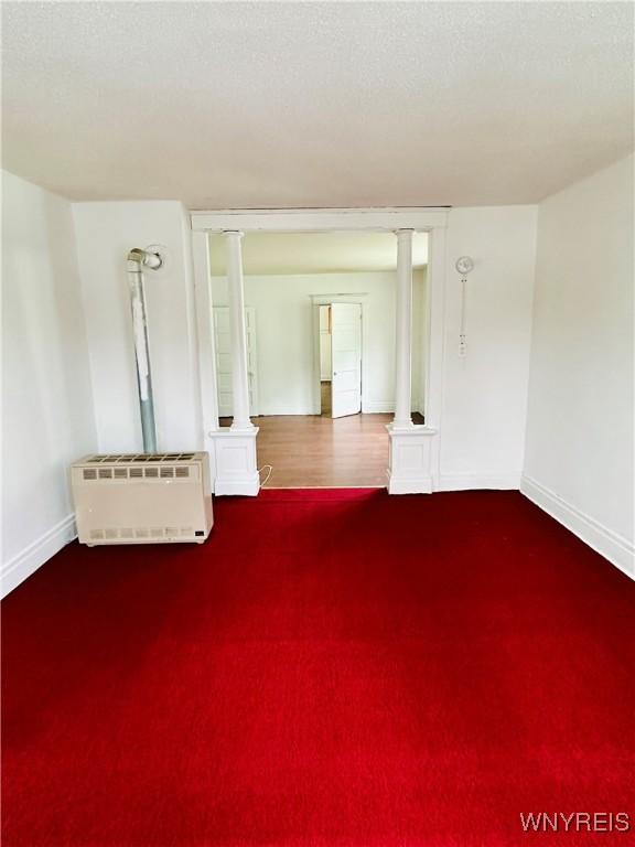 unfurnished living room featuring a textured ceiling and heating unit