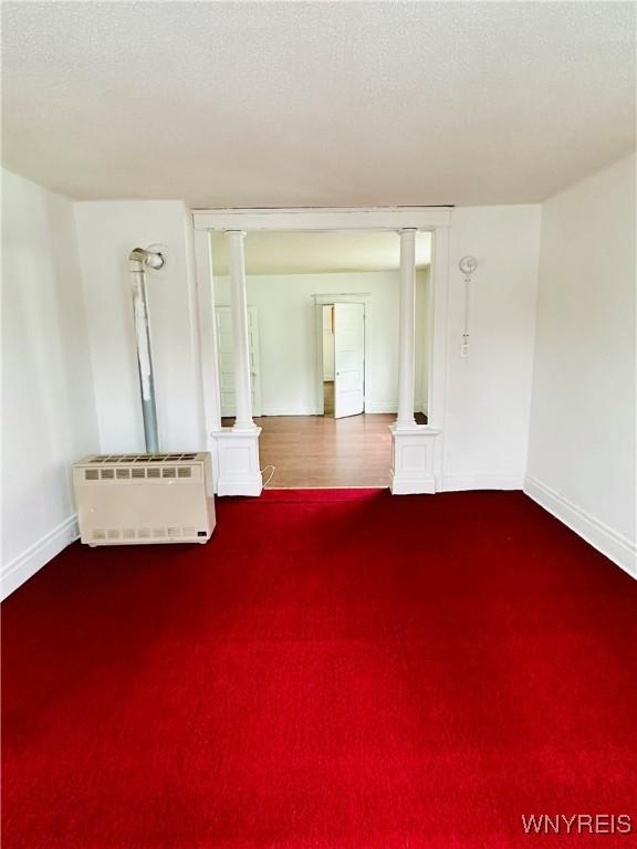 empty room featuring heating unit and a textured ceiling