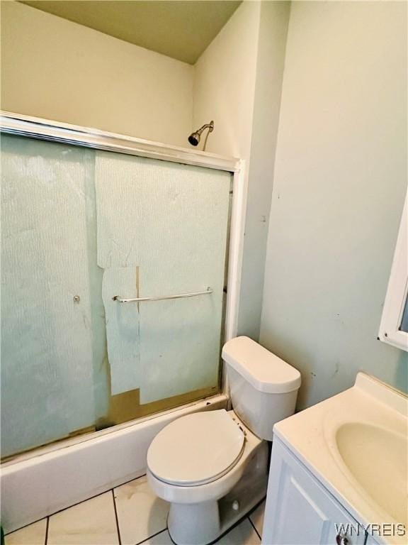 full bathroom featuring toilet, vanity, tile patterned floors, and combined bath / shower with glass door