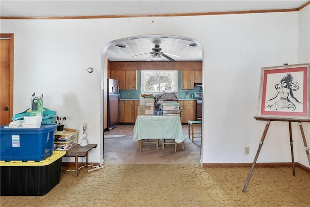 kitchen featuring carpet flooring, ceiling fan, crown molding, and appliances with stainless steel finishes