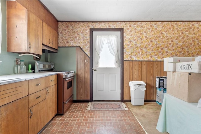 kitchen with range, crown molding, and wooden walls