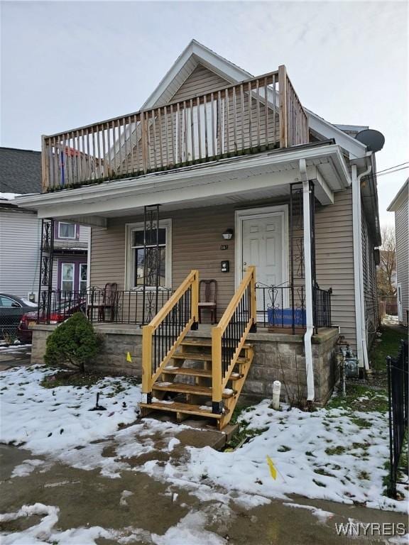 bungalow-style house featuring a porch and a balcony