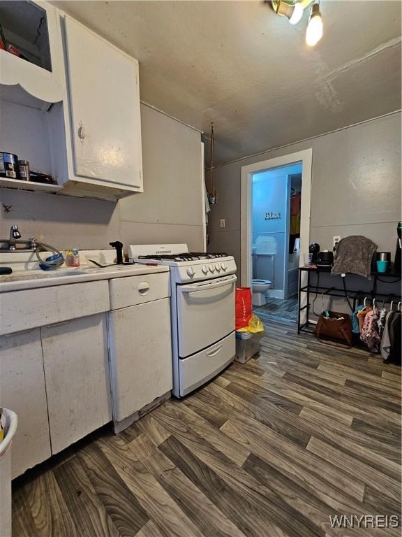 kitchen with dark hardwood / wood-style flooring, white cabinetry, and white range with gas cooktop