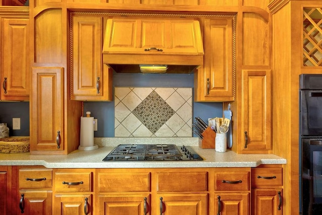 kitchen with tasteful backsplash, black gas stovetop, and custom range hood