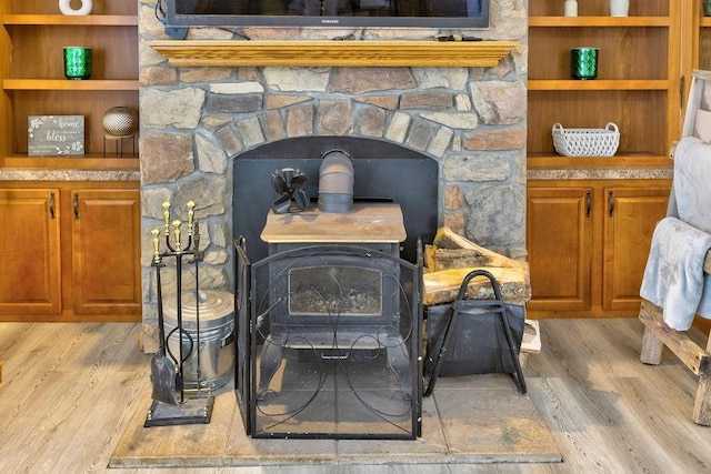 room details featuring hardwood / wood-style floors, built in features, and a wood stove