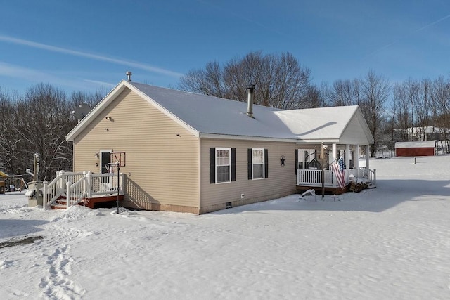 snow covered back of property with covered porch