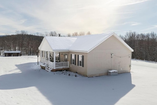 view of snow covered exterior featuring covered porch