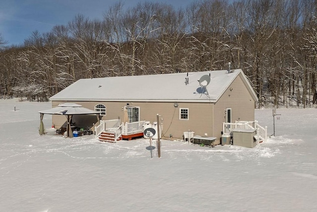 snow covered house with a gazebo and a wooden deck