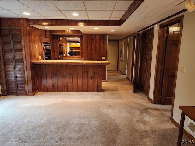 bar featuring light carpet and wood walls