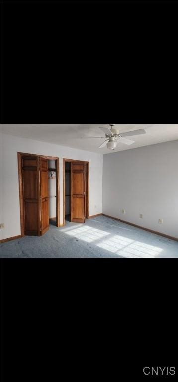 unfurnished bedroom featuring carpet floors, baseboards, and a ceiling fan