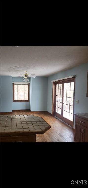 doorway to outside with ceiling fan and light wood-style flooring