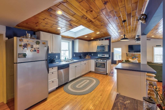 kitchen with a breakfast bar area, white cabinetry, stainless steel appliances, and a sink