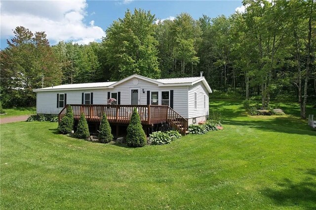 back of house with a deck and a lawn