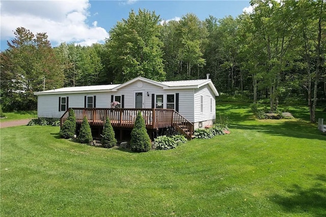 manufactured / mobile home featuring a front yard, metal roof, and a wooden deck