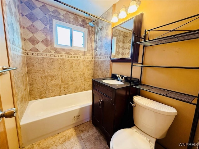 full bathroom with vanity, tiled shower / bath combo, and toilet