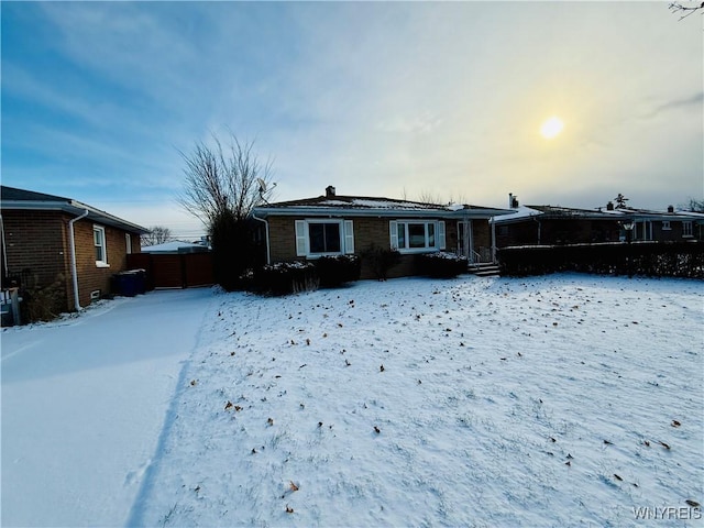 view of snow covered back of property