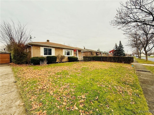 single story home featuring a front lawn