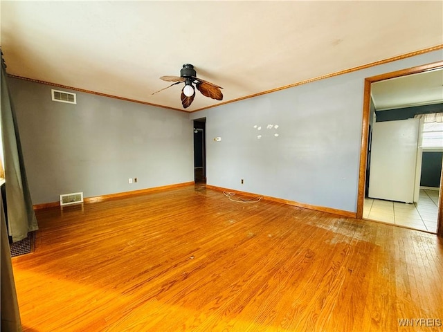 empty room with ceiling fan, light hardwood / wood-style flooring, and ornamental molding