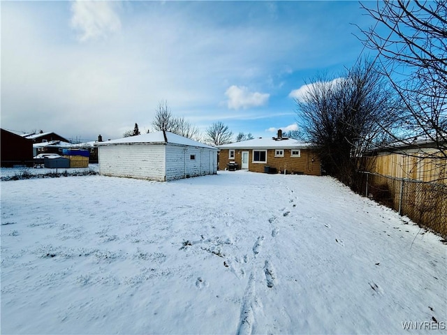 view of snow covered back of property