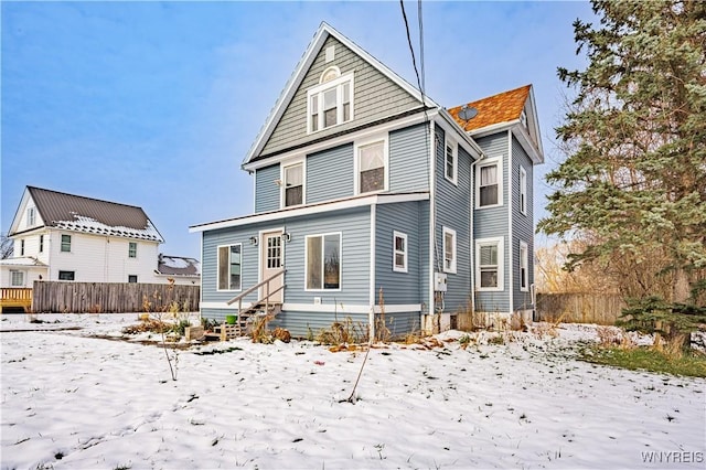 view of snow covered rear of property