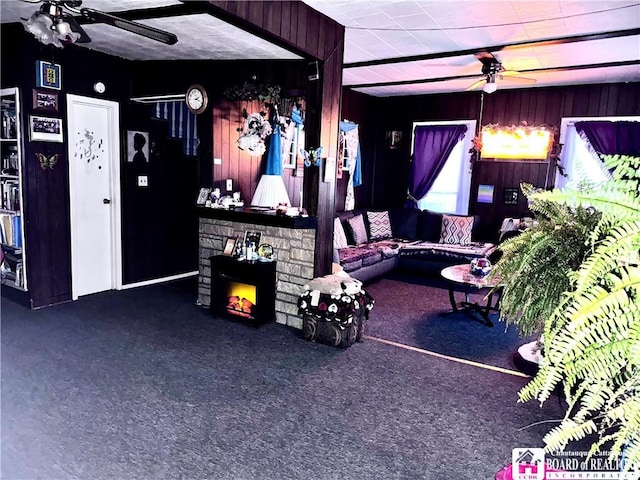 living room with dark colored carpet, ceiling fan, and a fireplace