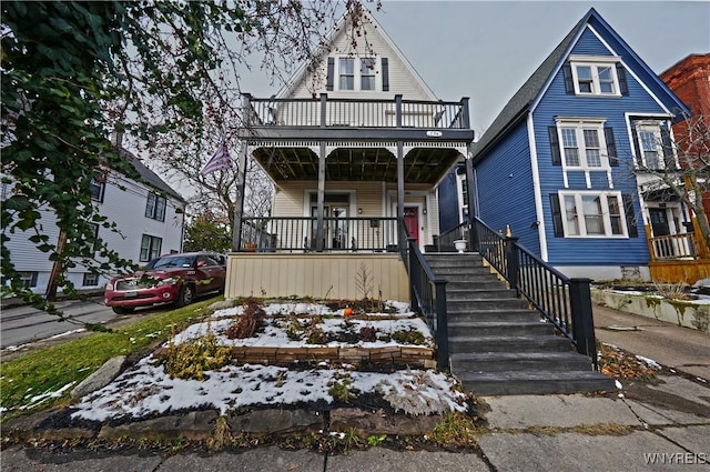 view of front of property with covered porch and a balcony