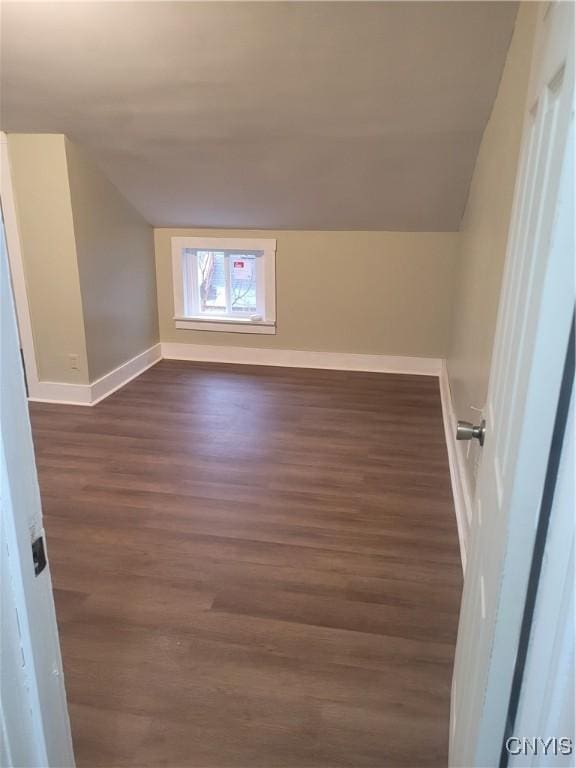 additional living space featuring dark hardwood / wood-style flooring and lofted ceiling