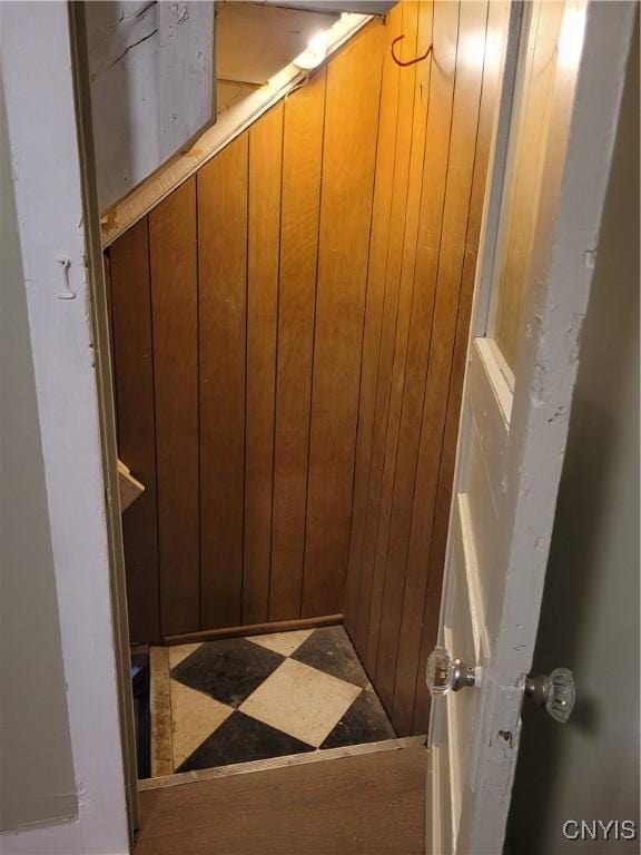 stairway featuring wooden walls