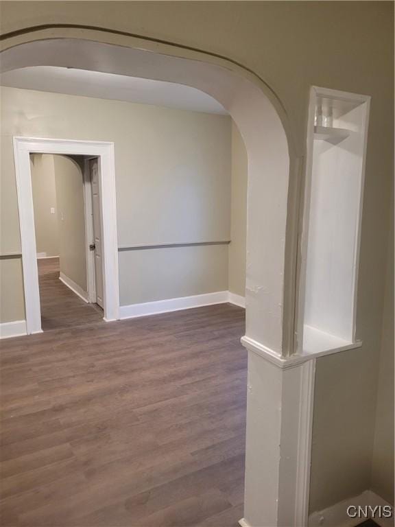 unfurnished room with dark wood-type flooring