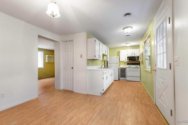 kitchen with white cabinetry, sink, beverage cooler, white appliances, and light wood-type flooring