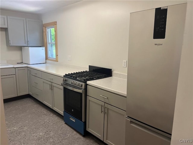 kitchen featuring gray cabinetry and appliances with stainless steel finishes